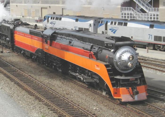 Streamlined steam locomotive with red and orange paint on the sides