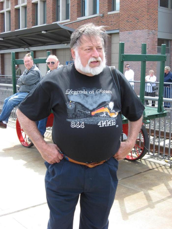 Man with white beard wearing black tee shirt with picture of 844 and 4449 steam locomotives
